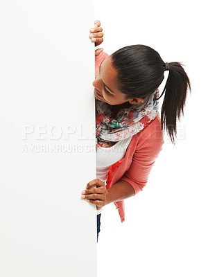 Buy stock photo Cute young woman peering around white copyspace