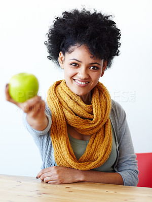 Buy stock photo Portrait of an attractive young woman holding out an apple