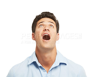 Buy stock photo A surprised young man looking upwards while isolated on a white background