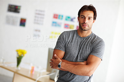 Buy stock photo Portrait of a handsome young man standing in an office with arms crossed