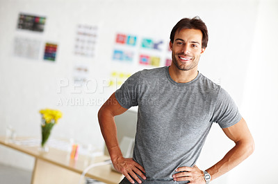 Buy stock photo Portrait of a smiling handsome man standing in his office with hands on his hips