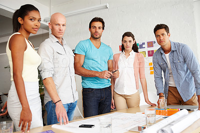 Buy stock photo Portrait of a group of designers gathered together around an office table to discuss their plans
