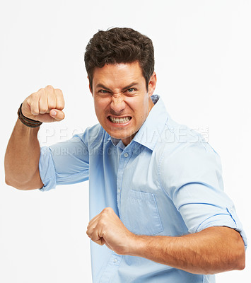 Buy stock photo An angry young man with fists clenched ready to punch against a white background 
