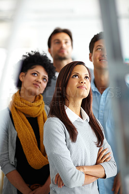 Buy stock photo A group of colleagues looking up at someone on a ladder 