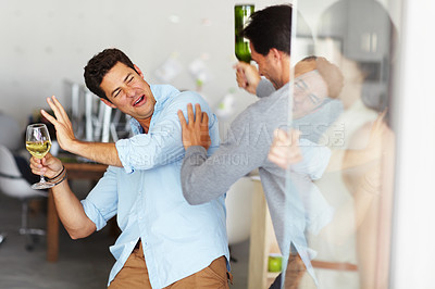 Buy stock photo Two dunk men holding a glass of wine and a wine bottle fight at an office social