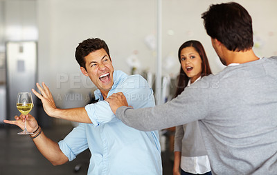 Buy stock photo A drunk man holding a glass of wine getting into a fight at an office social 