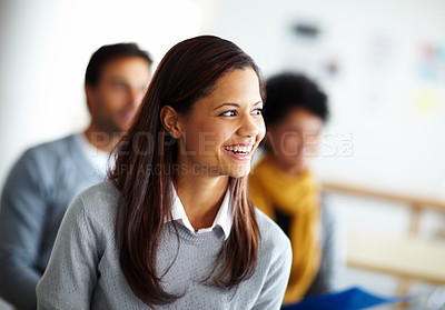 Buy stock photo A beautiful young woman sitting and listening to a presentation at work