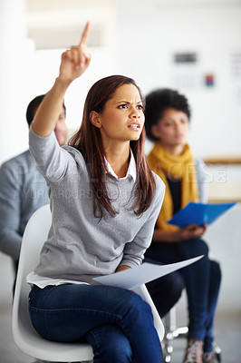 Buy stock photo A beautiful young woman sitting with her hand raised to ask a question 
