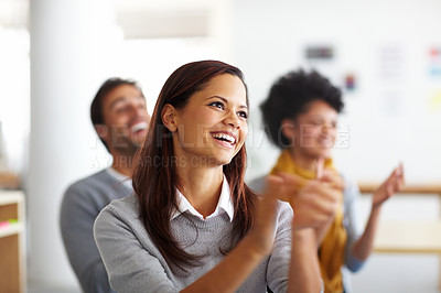 Buy stock photo A beautiful young woman sitting and applauding in admiration after listening to a presentation