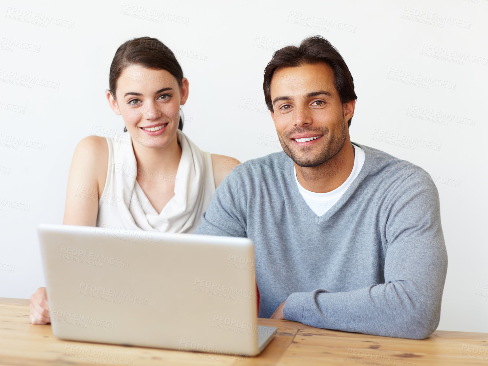 Buy stock photo Portrait of a handsome man and a beautiful young woman working together on a laptop