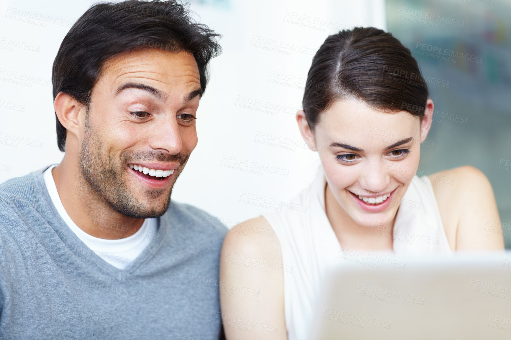 Buy stock photo A handsome man and a beautiful young woman working together on a laptop