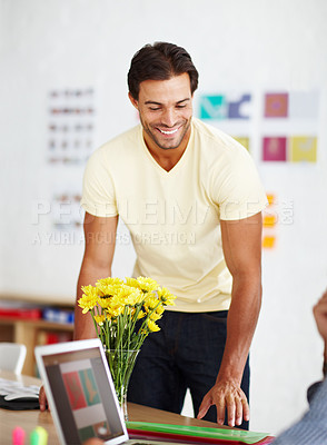 Buy stock photo A handsome young man talking to a colleague in his office