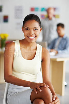 Buy stock photo Portrait of a confident young african american designer with her colleagues in the distance behind her