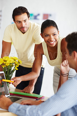 Buy stock photo Shot of a diverse group of designers discussing a project over a laptop