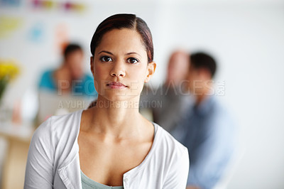 Buy stock photo Portrait of a serious-looking young professional with colleagues working in the background