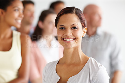 Buy stock photo Portrait of a young professional with her work colleagues standing behind her
