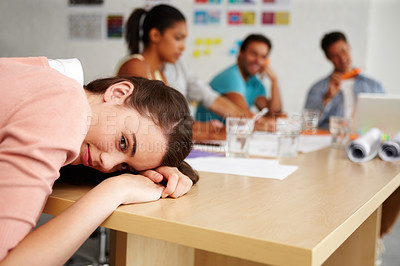 Buy stock photo Closeup up shot of a young intern resting her head on a boardroom table during a meeting