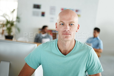 Buy stock photo Portrait of a confident young designer with his colleagues working in the background