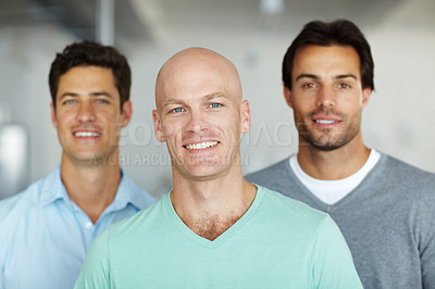 Buy stock photo Three young business creatives standing together and smiling in the office