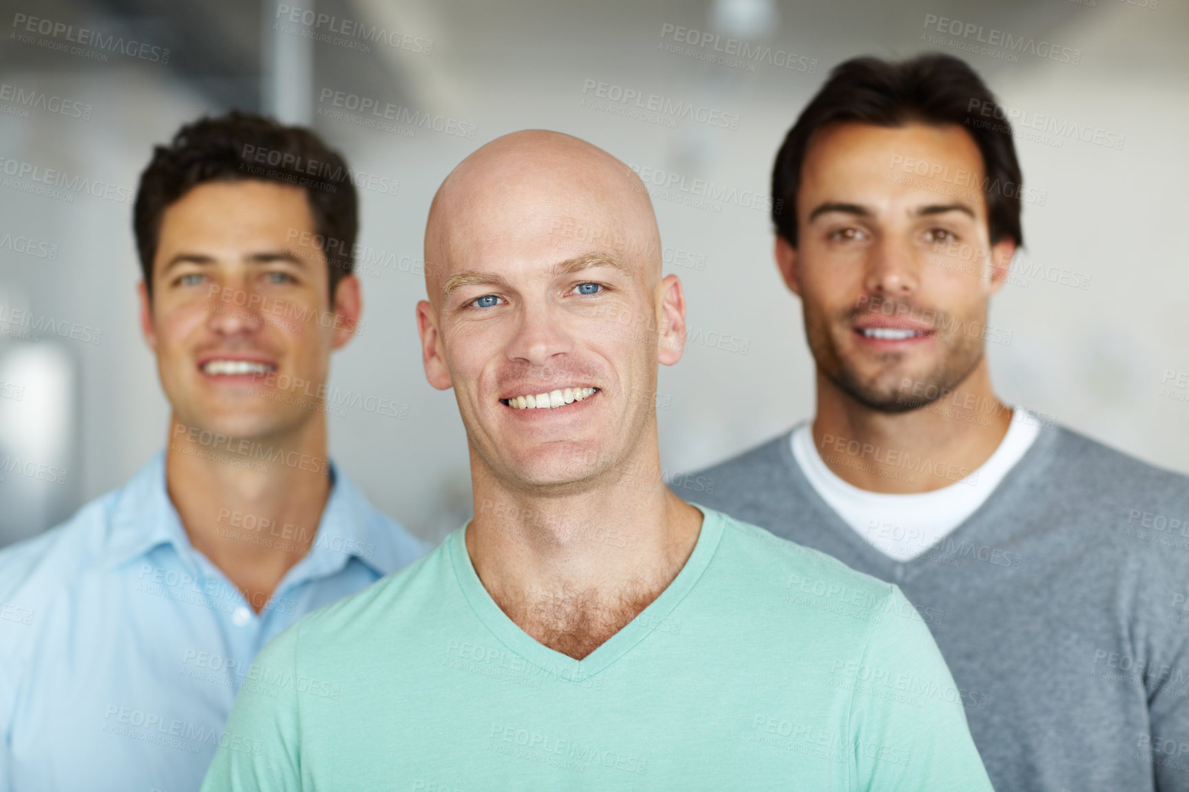 Buy stock photo Three young business creatives standing together and smiling in the office