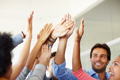 Buy stock photo Shot of a group of young office workers high-fiving each other