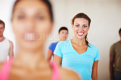 Buy stock photo A young woman smiling inbetween other members of her gym class