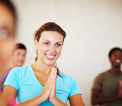 Buy stock photo A young woman smiling while doing a yoga pose in gym class