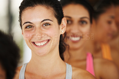 Buy stock photo Portrait of an attractive young yoga student standing in a row with other other students