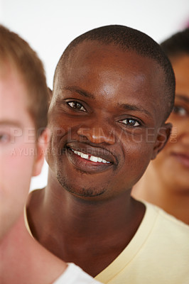 Buy stock photo Close up portrait of a young african american man standing in a line with other yoga students and smiling happily for the camera