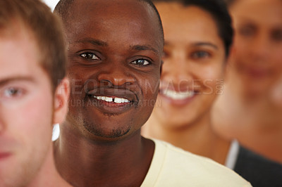 Buy stock photo Close up portrait of a young african american man standing in a line with other yoga students and smiling happily for the camera