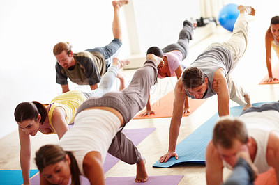 Buy stock photo A group of people working out on yoga mats. Yoga class multiracial group of women and men exercising healthy lifestyle in fitness studio yoga warrior poses
