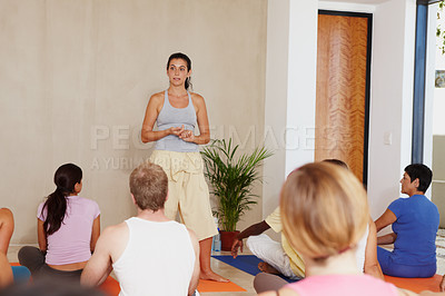 Buy stock photo Woman, yoga class and talk for coaching, group or presentation for health, wellness or self care. Personal trainer, speaker and people in audience, floor or pilates with training in morning at studio