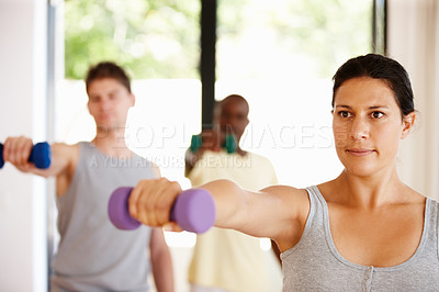 Buy stock photo Woman, dumbbell and exercise in pilates class, fitness and process with muscle development at gym. Person, weightlifting and group of people, balance and progress with training at wellness club