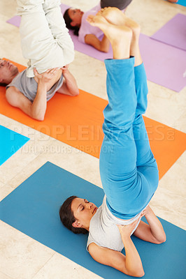 Buy stock photo A young woman lifting her legs into the air while lying on an exercise mat - Yoga
