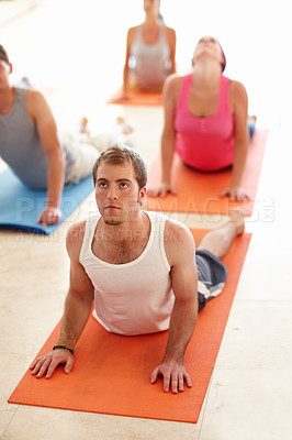 Buy stock photo A young man arching his back during a yoga routine