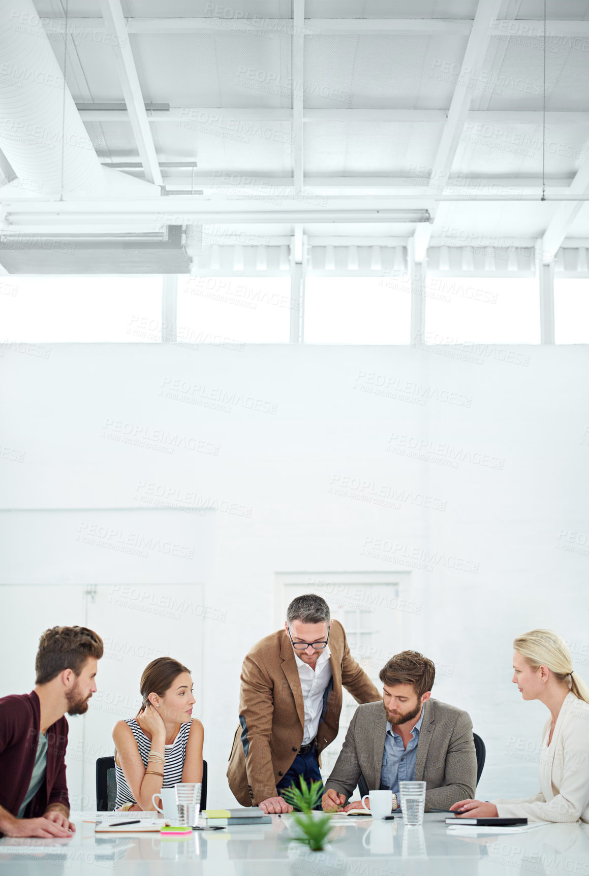 Buy stock photo A group of coworkers standing around a table
