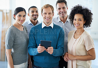 Buy stock photo Portrait of a group of diverse colleagues using a digital tablet while standing in an office