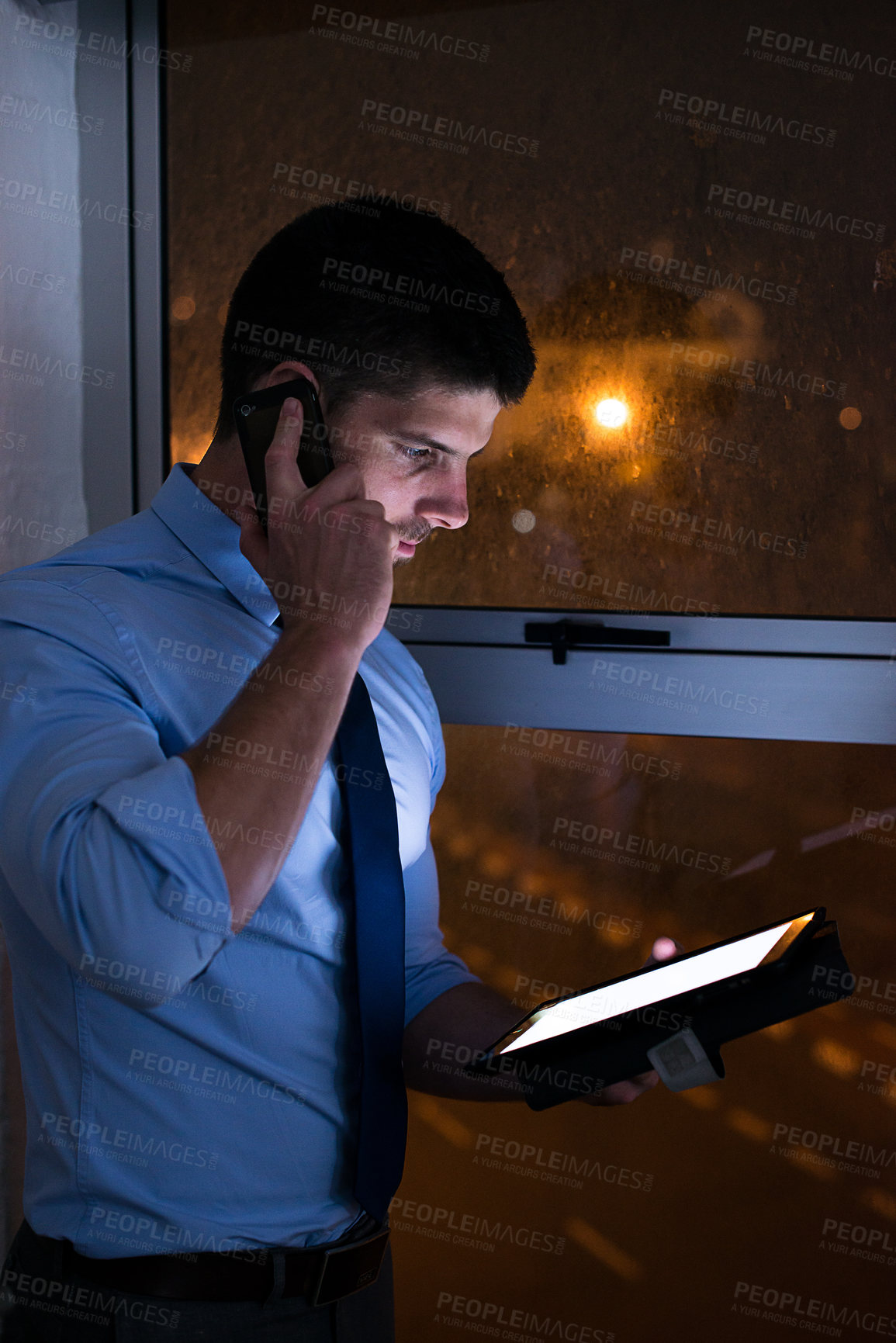 Buy stock photo Shot of a businessman talking on his cellphone late at night. Real life businesspeople shot on location. Since these locations are the real thing, and not shot in an 