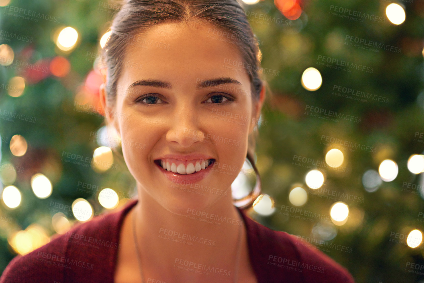 Buy stock photo Portrait of a beautiful young woman in front of a christmas tree