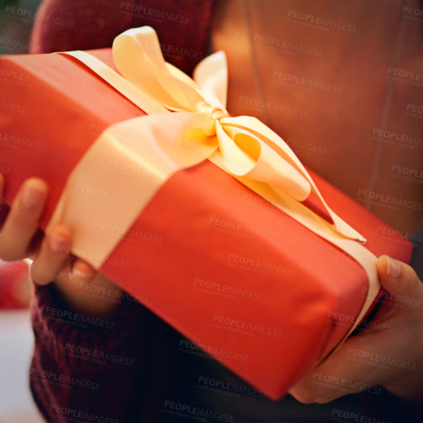 Buy stock photo Closeup shot of a woman holding a present wrapped in a bow