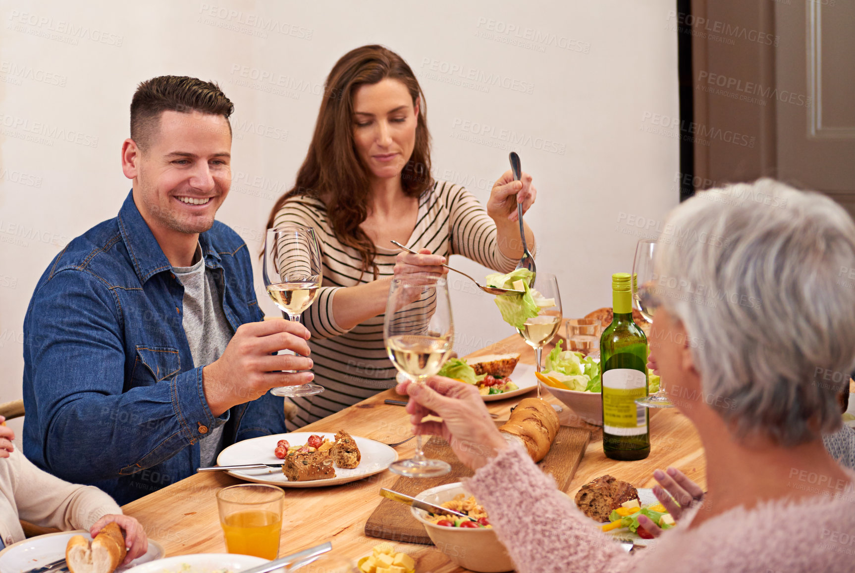 Buy stock photo Cropped shot of a family sharing a meal around the dinner table