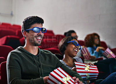 Buy stock photo Shot of a man and woman laughing while watching a 3D movie at the cinema
