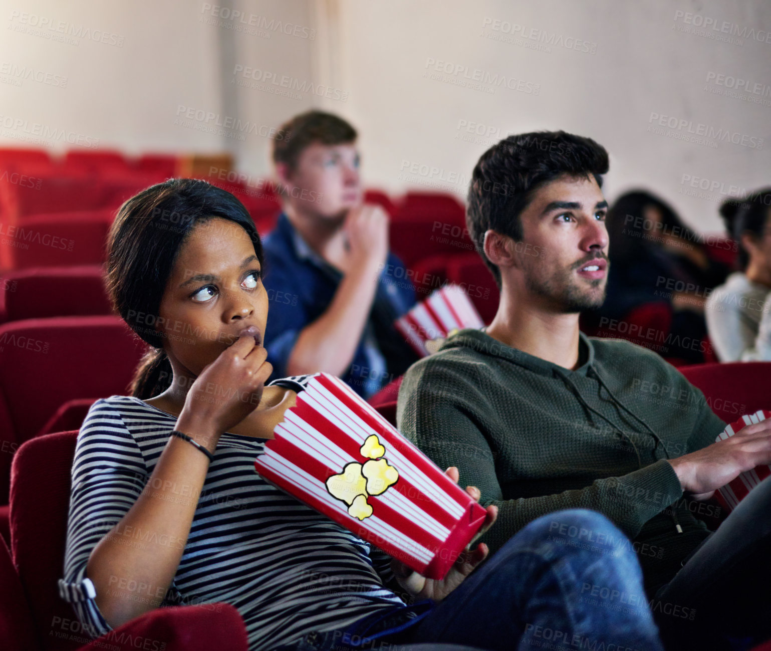 Buy stock photo Thriller, movie and couple in cinema on date with popcorn to relax and watch in theatre with suspense. Film, experience and people in audience enjoy horror, drama performance or eating snack food