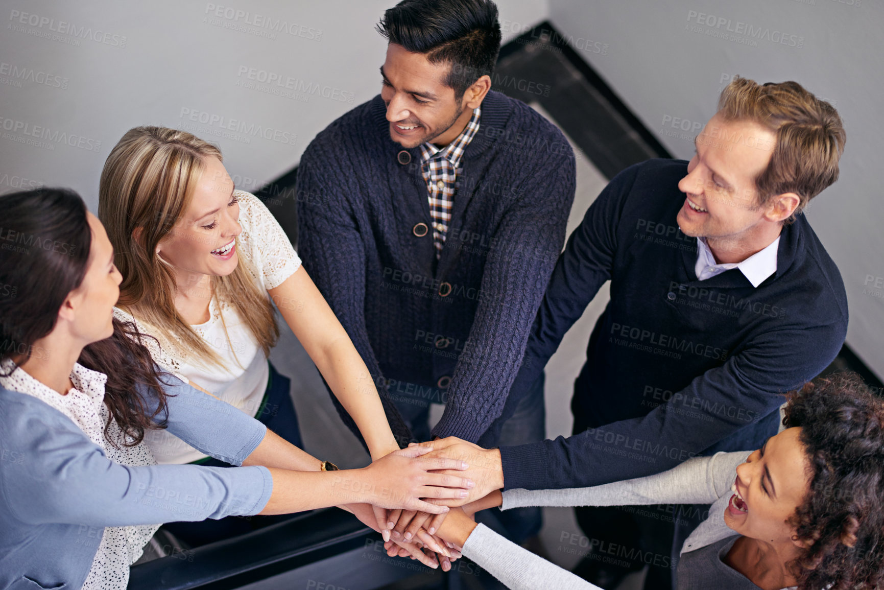 Buy stock photo Shot of a group of businesspeople in a huddle with their hands together
