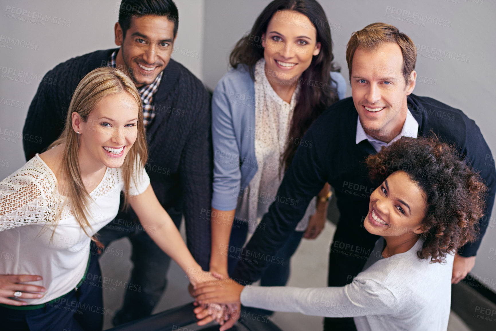 Buy stock photo Shot of a group of businesspeople in a huddle with their hands together