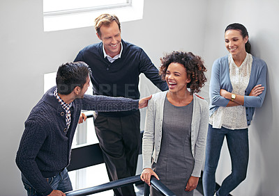 Buy stock photo Shot of a group of office coworkers standing in a stairwell chatting