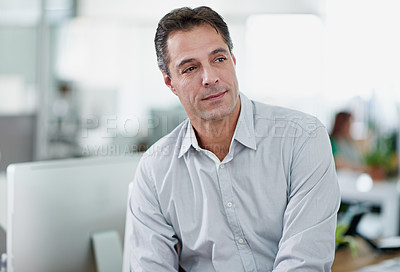 Buy stock photo Shot of a mature businessman sitting on his desk
