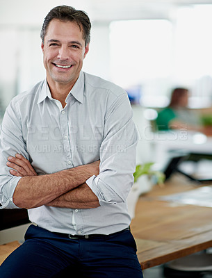 Buy stock photo Portrait of a smiling mature businessman sitting on his desk