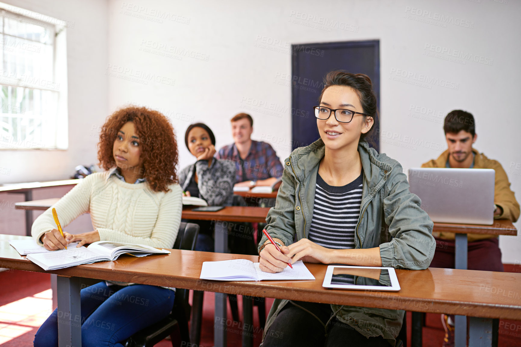 Buy stock photo Shot of a university students paying attention in class