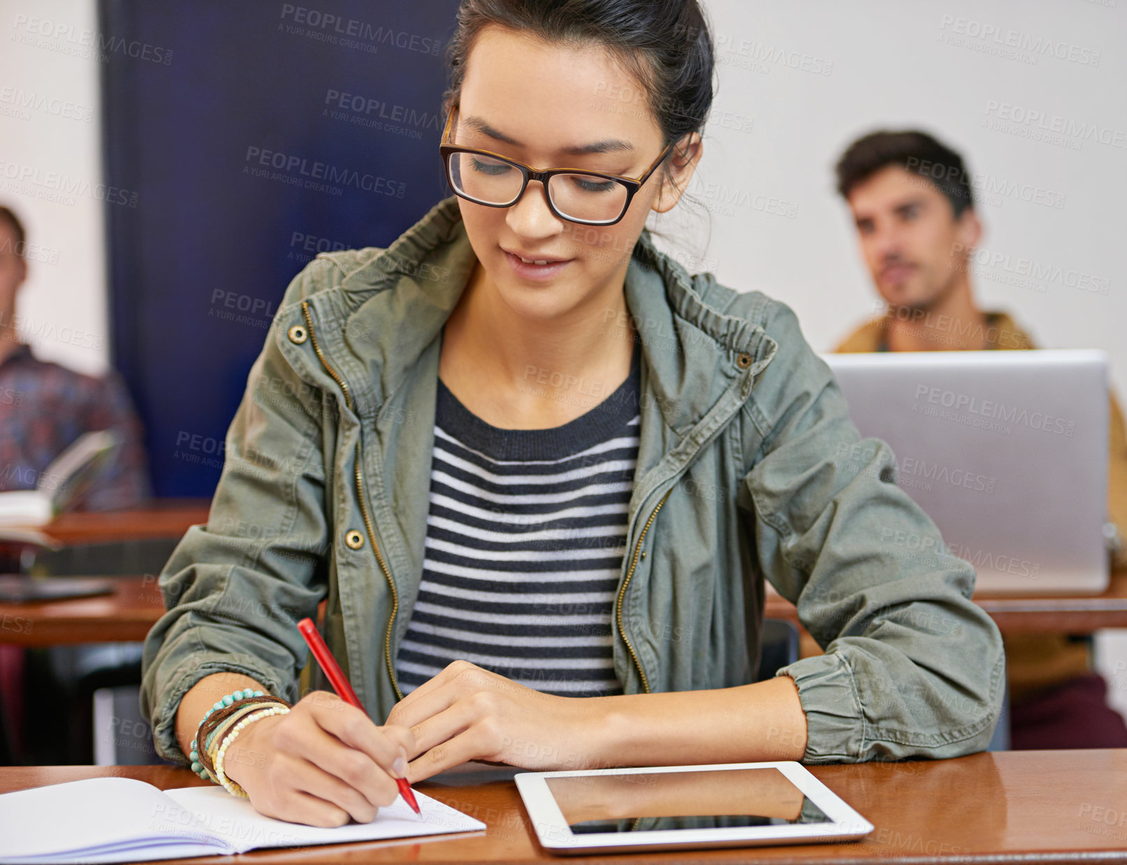 Buy stock photo Cropped shot of a young woman using notes and digital tablet in class